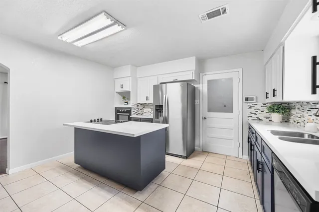 a kitchen with kitchen island a sink stove and refrigerator