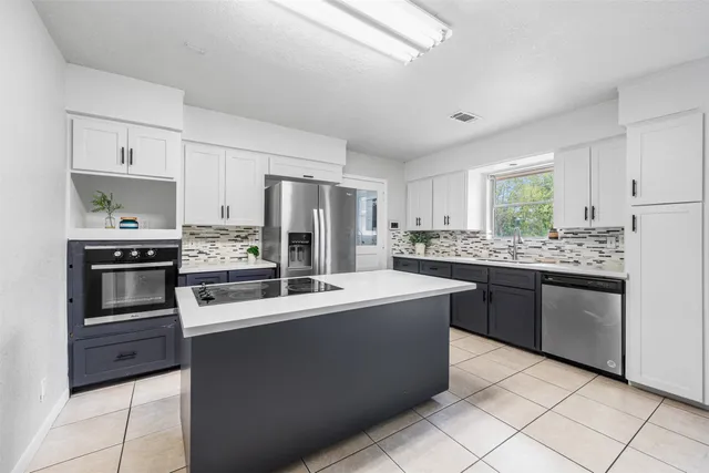 a kitchen with kitchen island granite countertop cabinets and stainless steel appliances