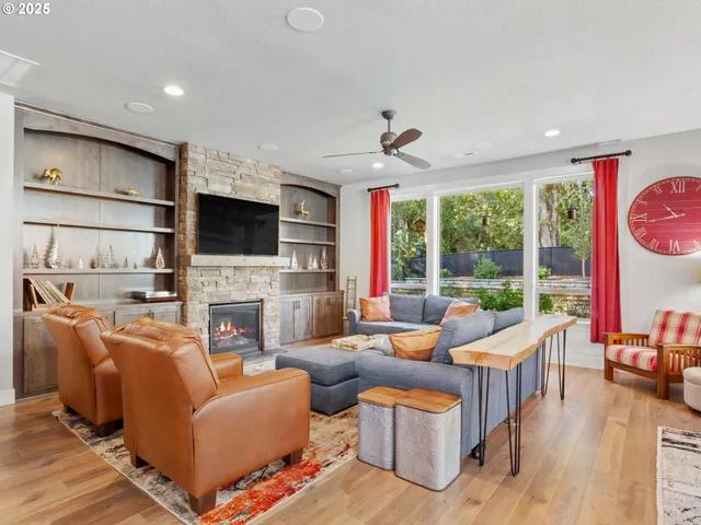 a living room with fireplace furniture and a large window