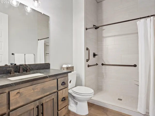a bathroom with a granite countertop sink toilet and shower