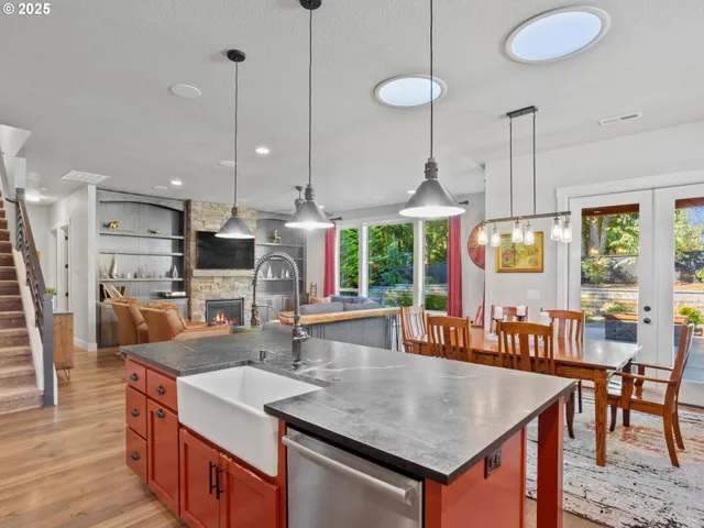 a kitchen with stainless steel appliances granite countertop a sink a stove and a wooden floors