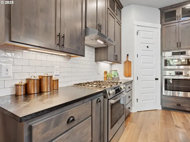 a kitchen with stainless steel appliances granite countertop a sink stove and refrigerator