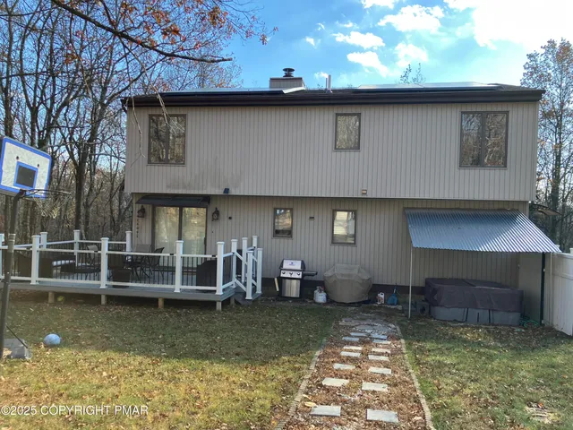 a view of a backyard with table and chairs and a large tree
