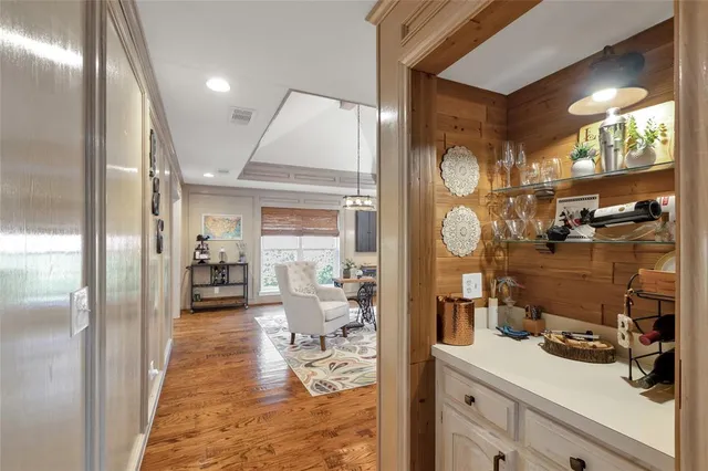 a hallway with a view of living room with furniture and a large window
