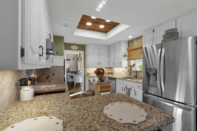 a kitchen with stainless steel appliances granite countertop a refrigerator sink and stove