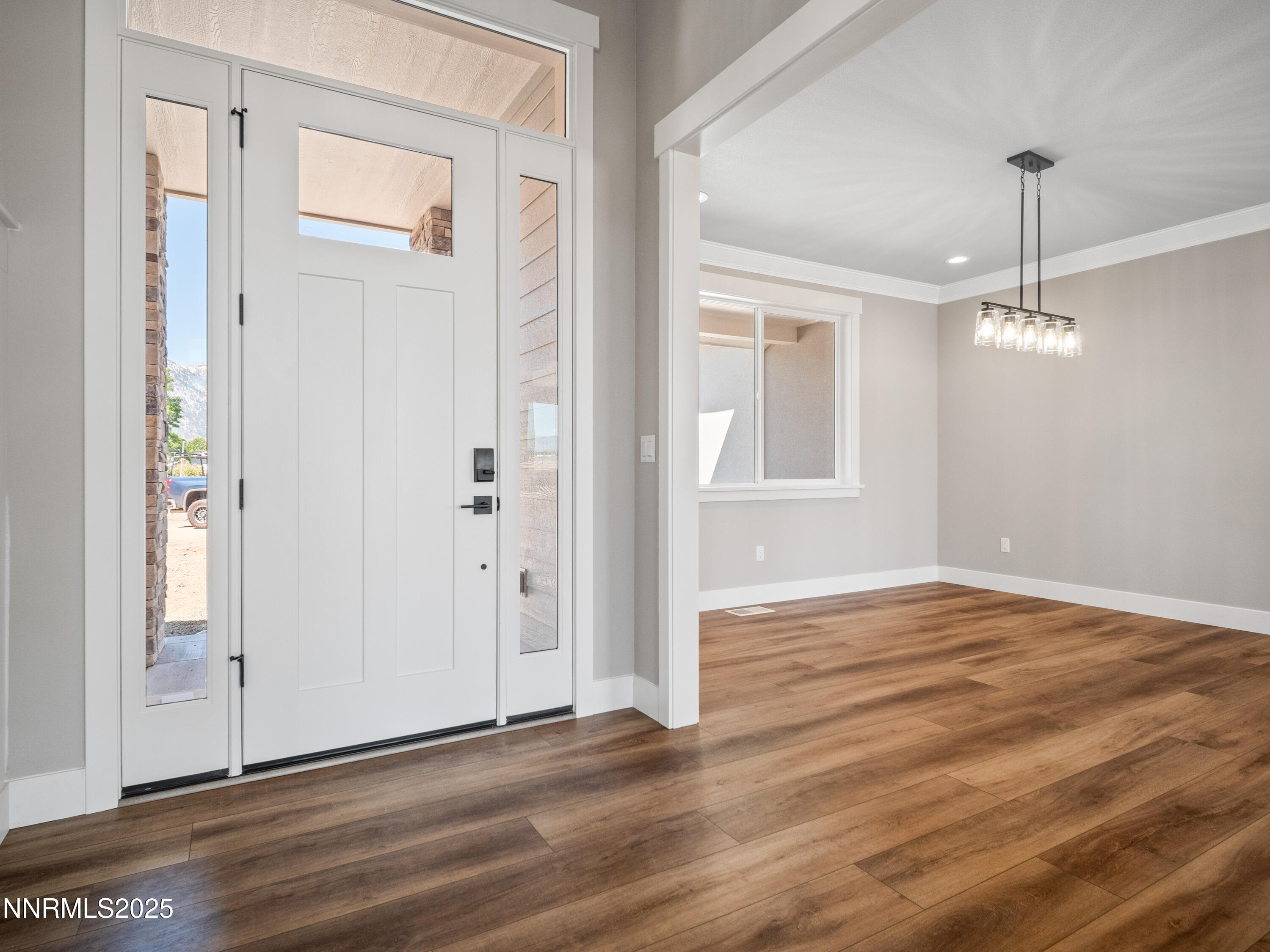781 Rubio Way Gardnerville, NV 89460 - Photo 3 of 61 an empty room with wooden floor mirror and windows