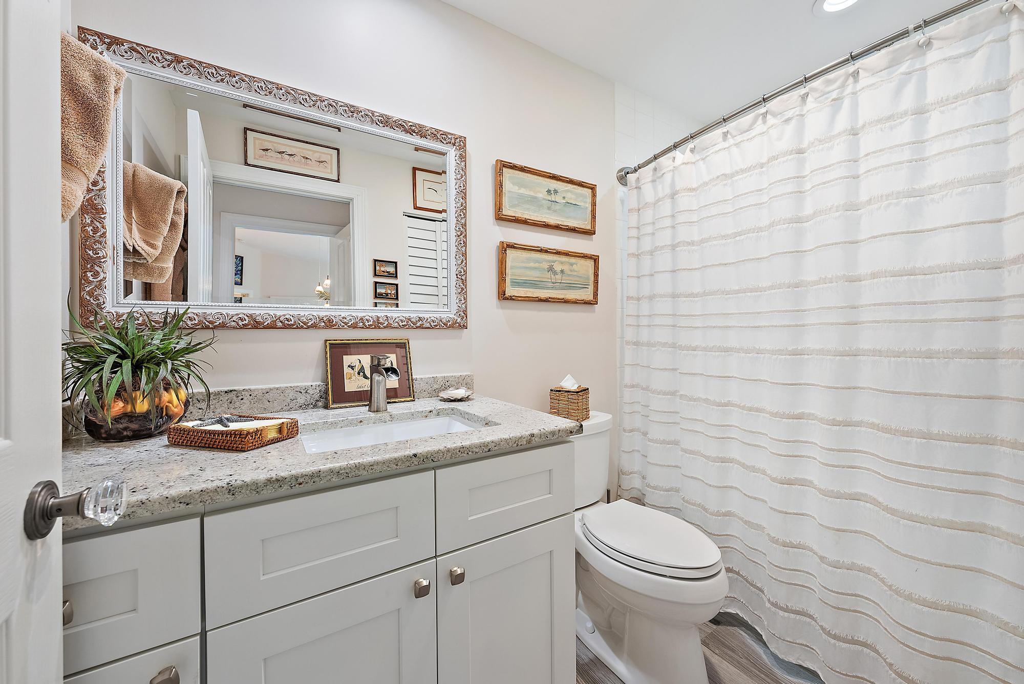 197 Brier Circle Jupiter, FL 33458 - Photo 18 of 33 a bathroom with a granite countertop sink a toilet and a mirror