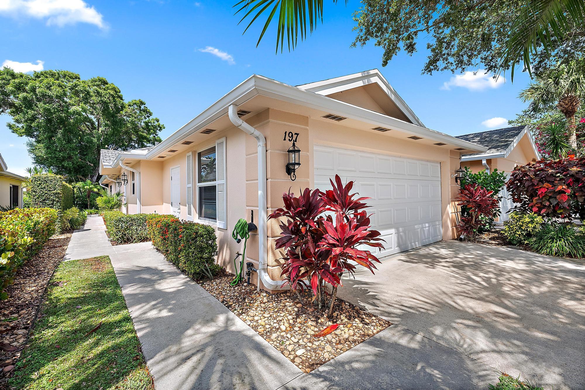 197 Brier Circle Jupiter, FL 33458 - Photo 25 of 33 a front view of a house with a yard and potted plants