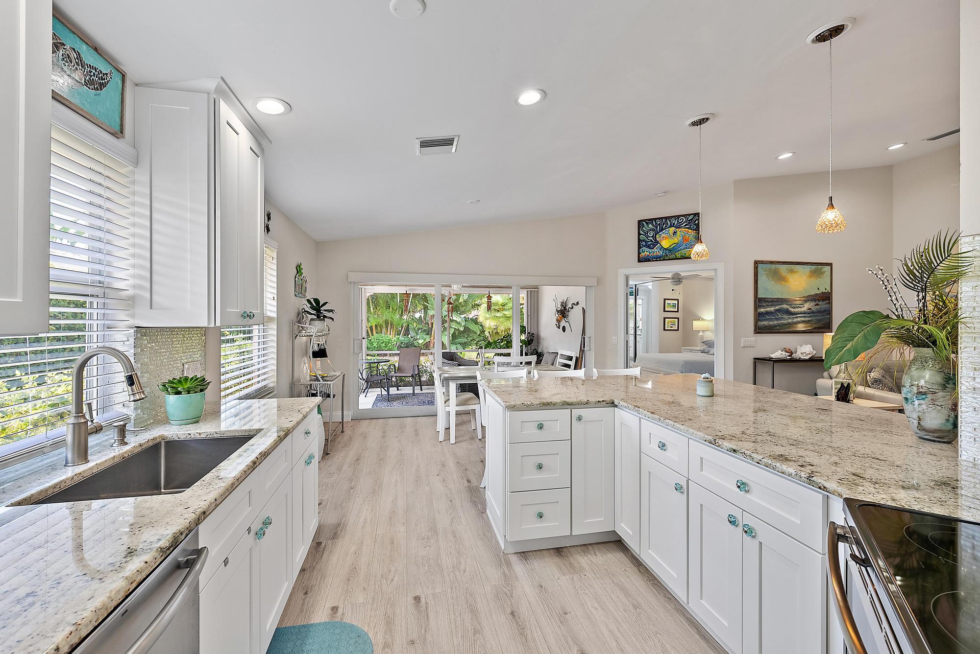 197 Brier Circle Jupiter, FL 33458 - Photo 4 of 33 a large kitchen with granite countertop a sink a counter space appliances and cabinets