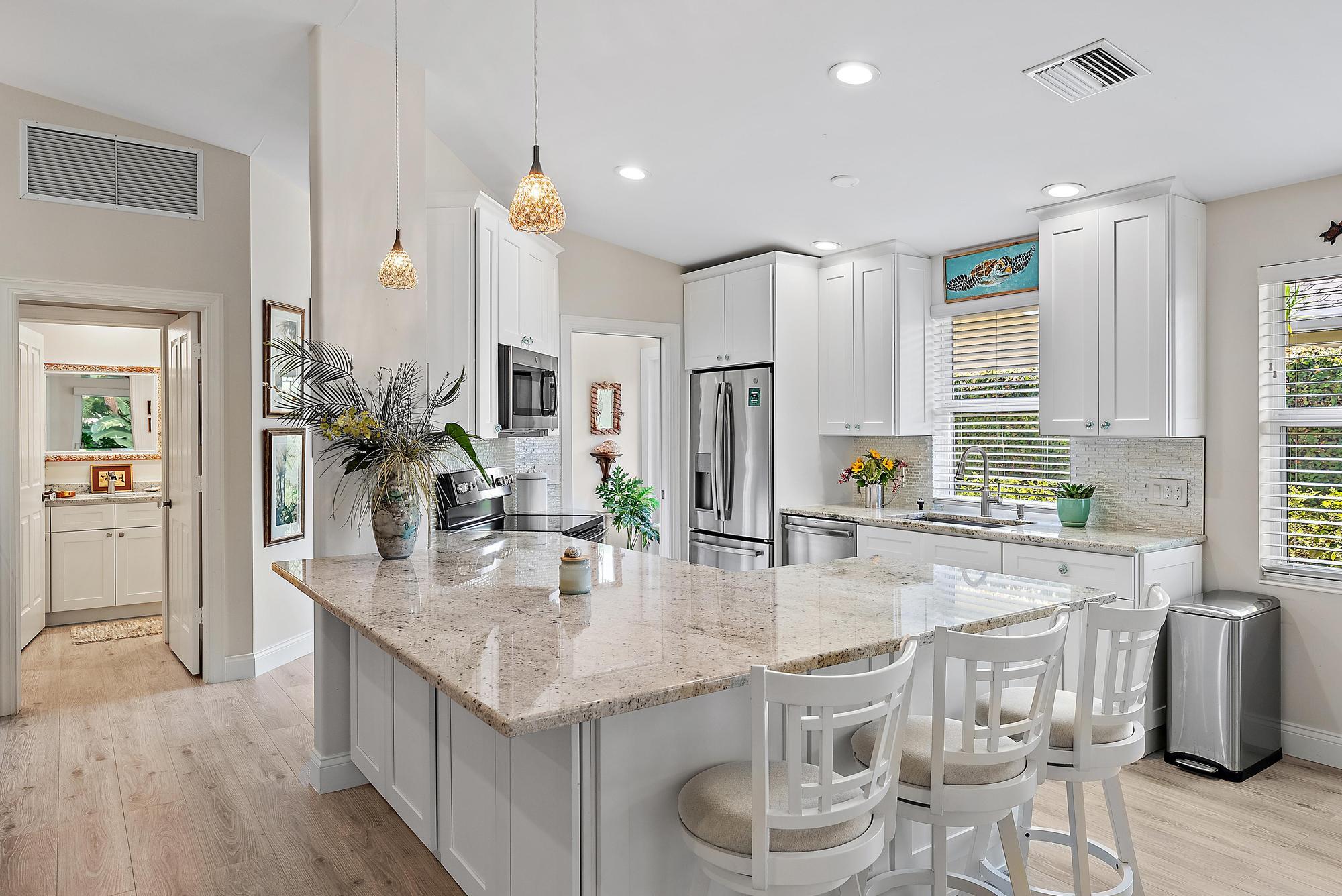 197 Brier Circle Jupiter, FL 33458 - Photo 5 of 33 a kitchen with granite countertop kitchen island stainless steel appliances a sink and cabinets