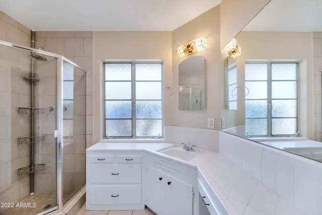 a bathroom with a double vanity sink and large mirror