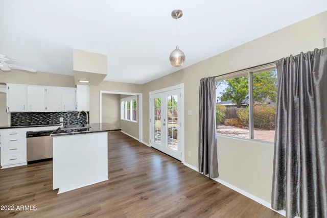 an empty room with wooden floor and a large window