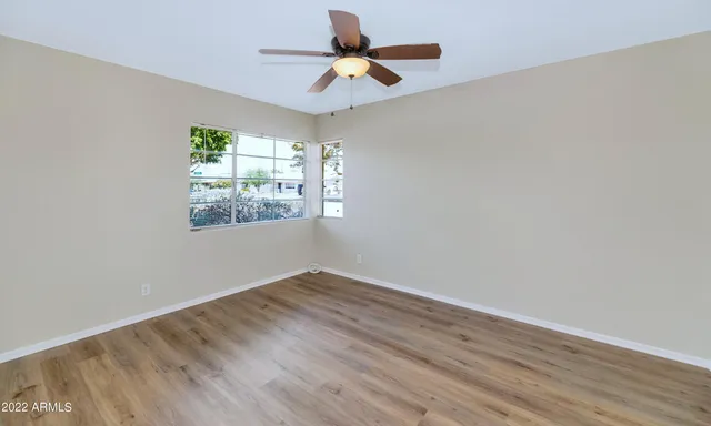 a view of an empty room with window and wooden floor