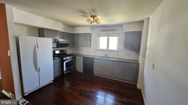 a kitchen with a refrigerator sink and cabinets