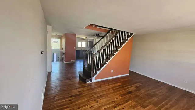 a view of a hallway with wooden floor and staircase