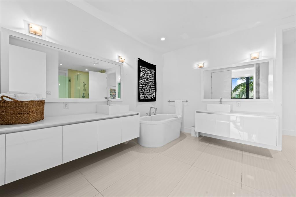 60 Hendricks Isle, Unit 301 Fort Lauderdale, FL 33301 - Photo 11 of 31 a large white room with a large mirror and vanity