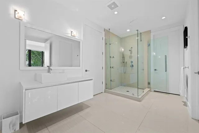 a bathroom with a shower sink and mirror