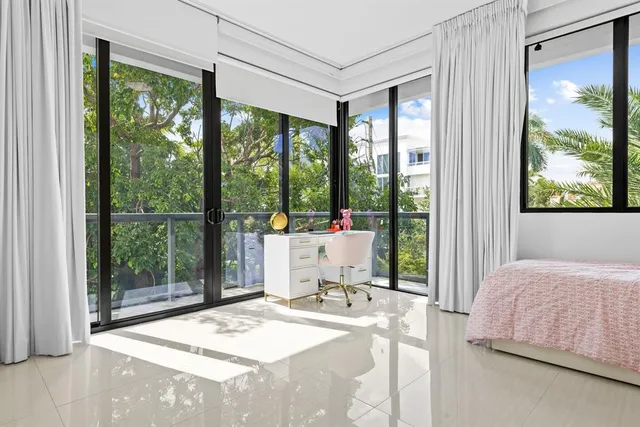 a bedroom with a bed and large windows