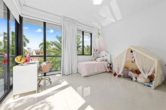 a bedroom with furniture and a large window