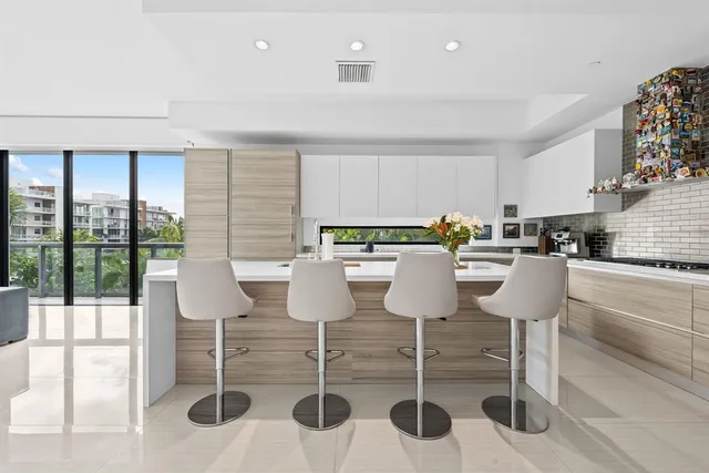 a kitchen with stainless steel appliances kitchen island granite countertop a table and chairs