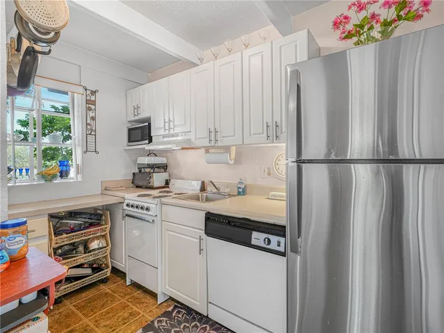 a kitchen with stainless steel appliances a refrigerator sink and cabinets