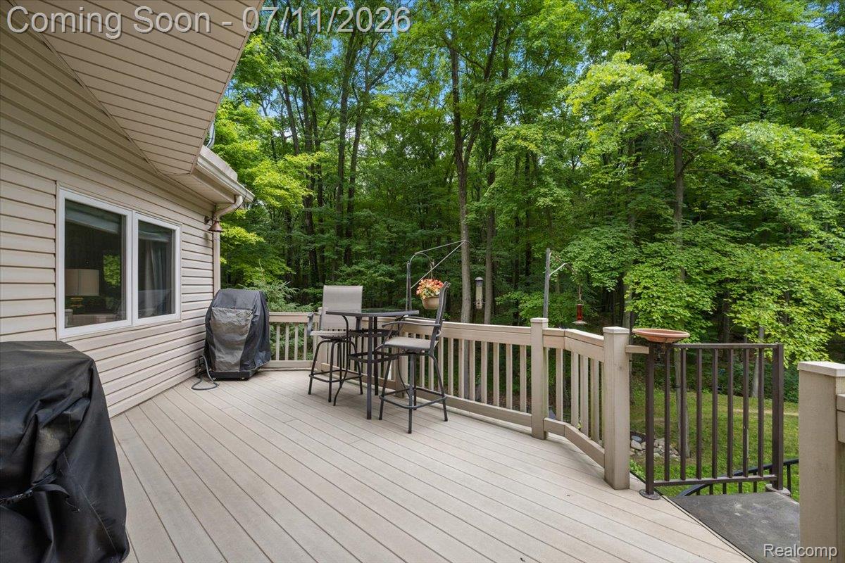 4219 Gardner Road Metamora, MI 48455 - Photo 67 of 87 Expansive outdoor deck with composite decking and light-colored railing, offering a serene backdrop of mature trees