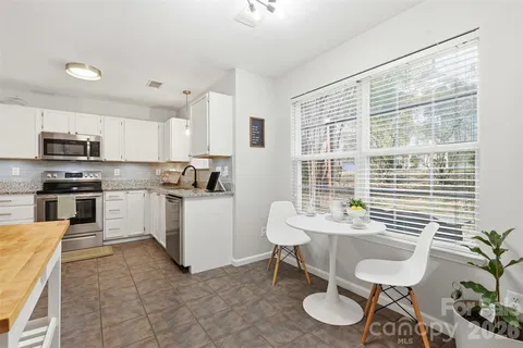 a kitchen with granite countertop a sink and white appliances