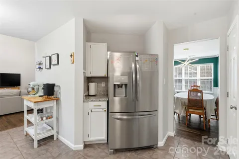 a kitchen with stainless steel appliances a refrigerator a stove a dining table and chairs