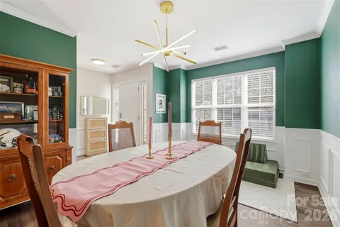 a bedroom with a bed a table and large window