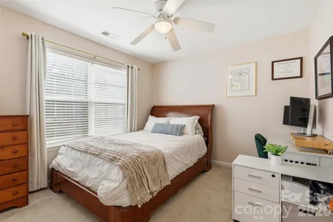 a bedroom with a bed a flat screen tv and a window