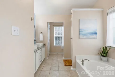 a spacious bathroom with a granite countertop tub sink and mirror