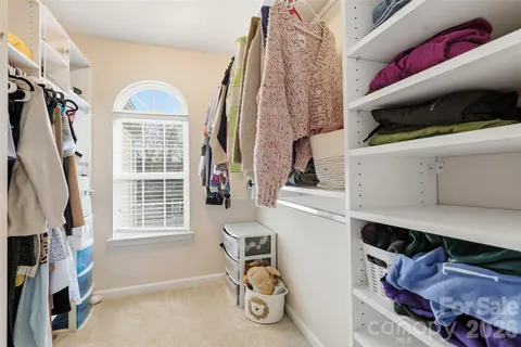 a view of walk in closet with clothes and shoes