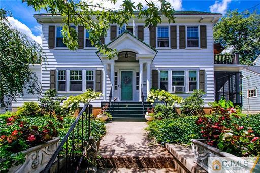 a front view of a house with a yard and potted plants