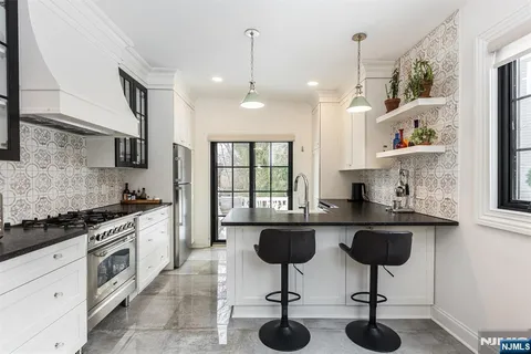 a kitchen with granite countertop white cabinets and white appliances
