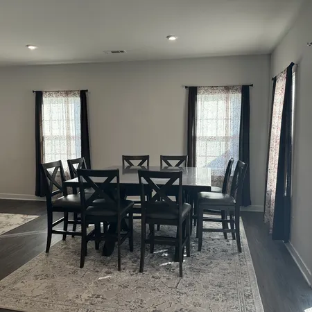 a view of a a dining room with furniture window and wooden floor
