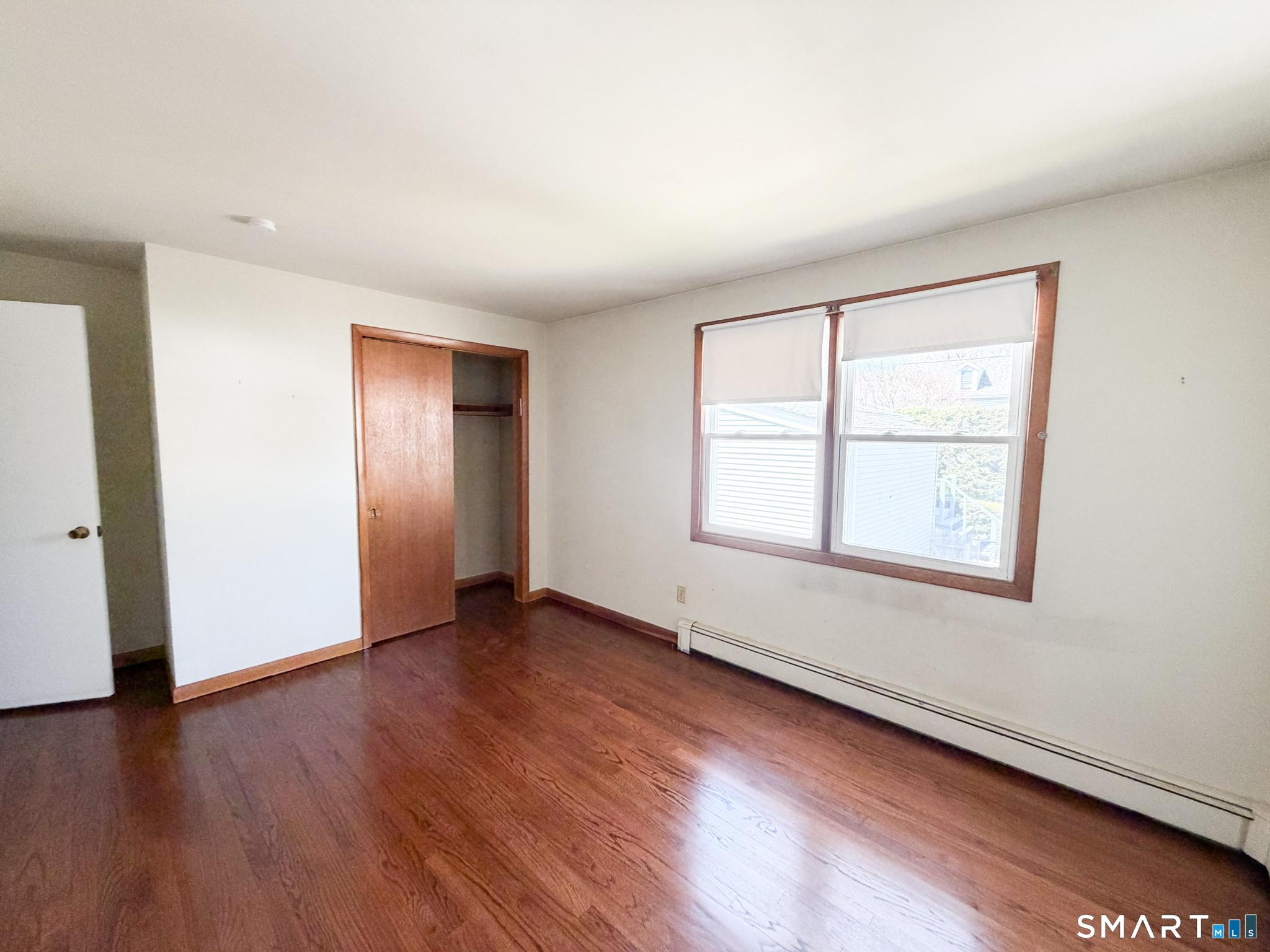 732 Tunxis Hill Road Fairfield, CT 06825 - Photo 13 of 21 an empty room with wooden floor and windows