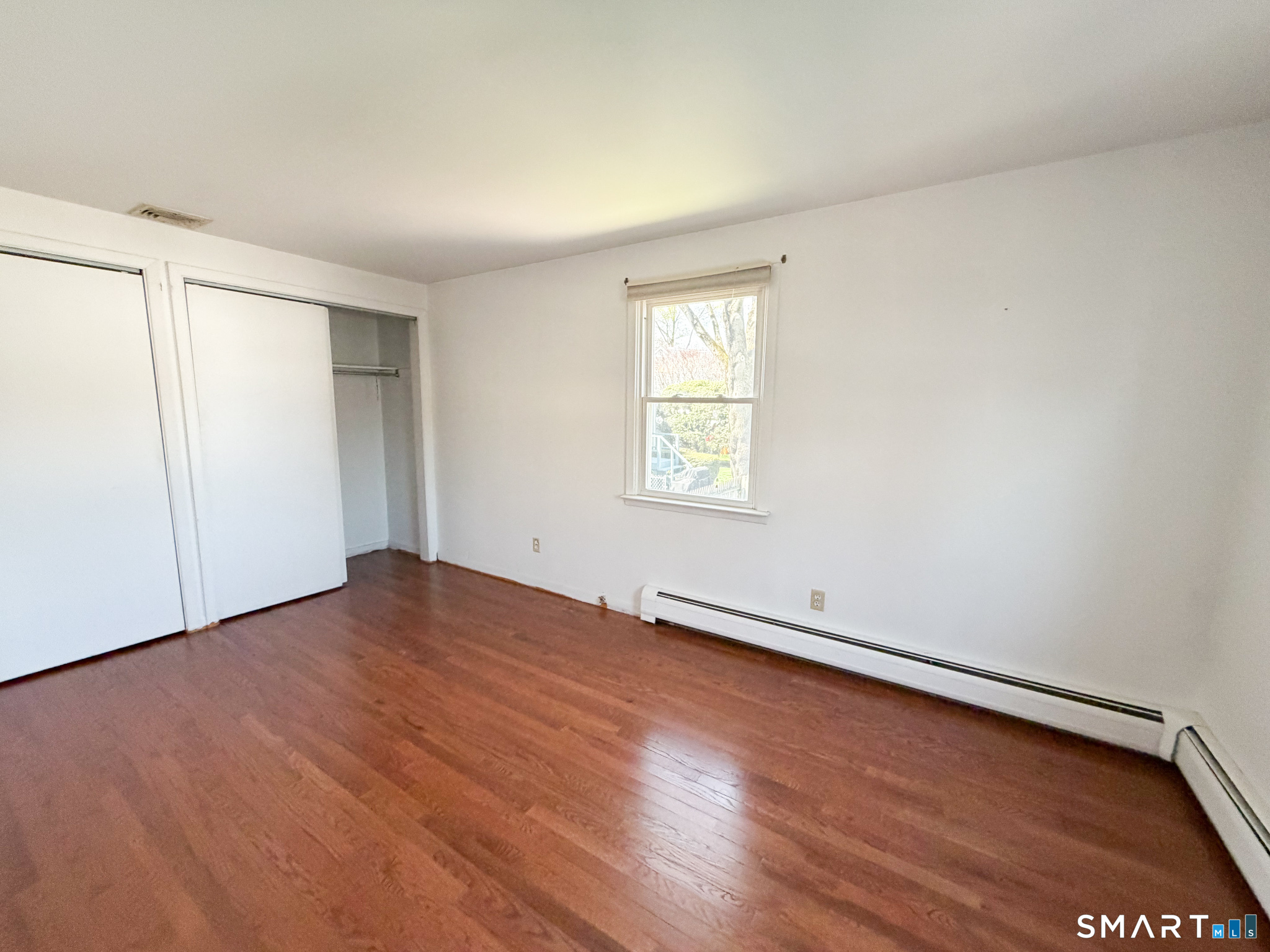 732 Tunxis Hill Road Fairfield, CT 06825 - Photo 17 of 21 an empty room with wooden floor and windows
