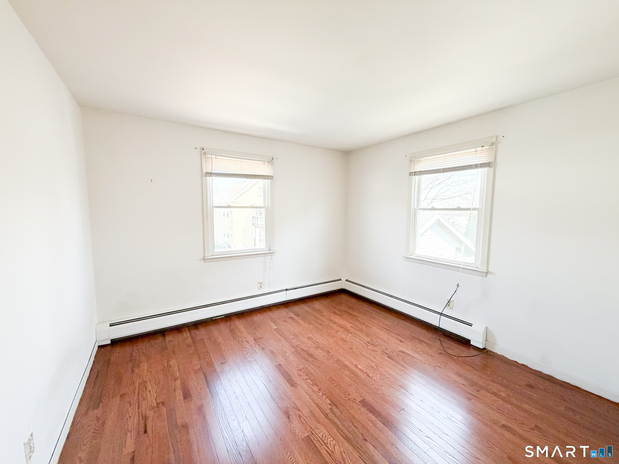 732 Tunxis Hill Road Fairfield, CT 06825 - Photo 18 of 21 an empty room with wooden floor and windows
