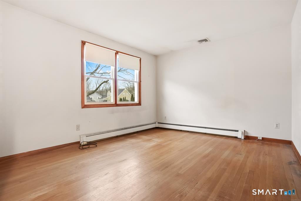 732 Tunxis Hill Road Fairfield, CT 06825 - Photo 9 of 21 an empty room with a floor to ceiling window and wooden floor