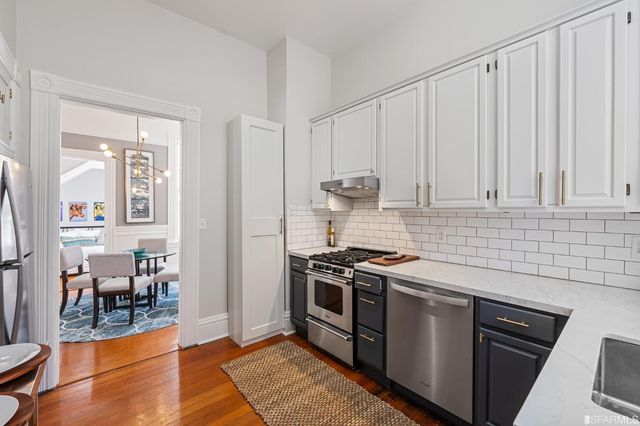 a kitchen with stainless steel appliances granite countertop a stove a sink and a refrigerator
