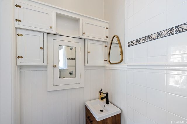 a white bathroom with a sink and a mirror