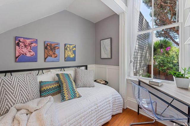 a bed sitting in a bedroom next to a window