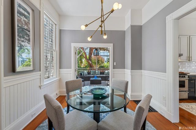 a dining room with furniture a chandelier and wooden floor