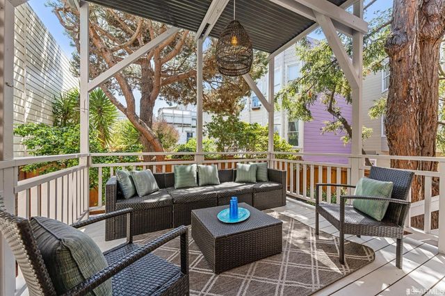 a view of a patio with couches chairs and wooden floor
