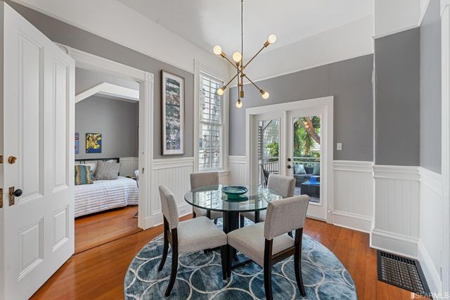 a dining room with furniture a chandelier and wooden floor
