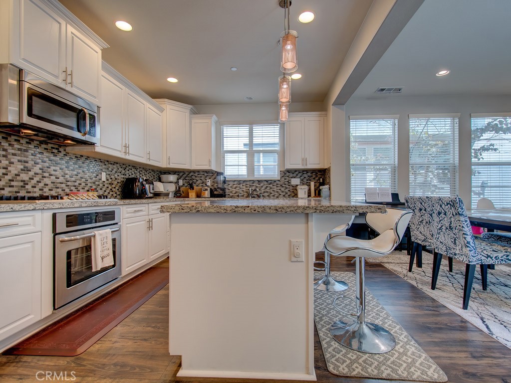 147 Acamar Irvine, CA 92618 - Photo 17 of 52 a kitchen with a table chairs microwave and cabinets