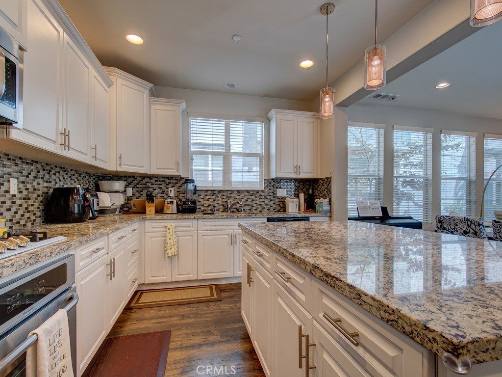 147 Acamar Irvine, CA 92618 - Photo 19 of 52 a kitchen with stainless steel appliances granite countertop wooden cabinets a stove a sink and a granite counter tops