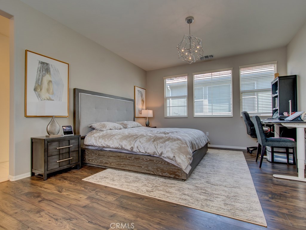 147 Acamar Irvine, CA 92618 - Photo 38 of 52 a spacious bedroom with a large bed and a chandelier
