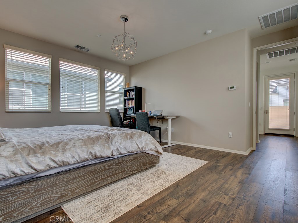 147 Acamar Irvine, CA 92618 - Photo 39 of 52 a spacious bedroom with a bed chandelier and a window