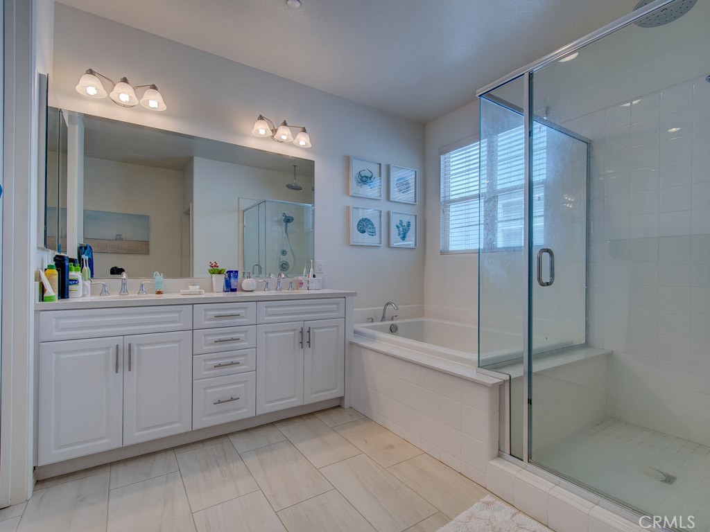 147 Acamar Irvine, CA 92618 - Photo 40 of 52 a spacious bathroom with a double vanity sink a mirror a bathtub and shower